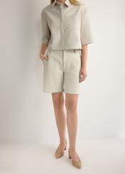 Skórzane kremowe szorty damskie SPODS-0047-0B(W26), widok produktu z przodu na modelce. Widoczna połowa sylwetki.