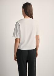 Bawełniany kremowy T-shirt damski TSHDT-0138-0B(W26), widok produktu od tyłu na modelce, widoczna połowa sylwetki.