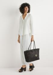 Brązowa skórzana pleciona torebka TORES-1300-1H(W26) - widok produktu z przodu, trzymanego przez modelkę w ręku, na jasnym tle. 