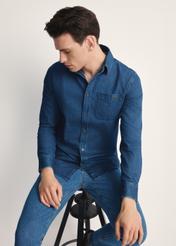 Niebieska jeansowa koszula męska KOSMT-0348-61(Z25), produkt widoczny od przodu na modelu, widoczne pół sylwetki.