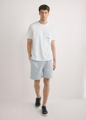 Biały T-shirt męski z nadrukiem TSHMT-0145-0A(W26), widok produktu z przodu na modelu. Widoczna cała sylwetka.