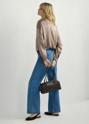 Ciemnobrązowa torebka na ramię TOREC-1233-1I(W26), widok produktu w dłoni modelki. Widoczna cała sylwetka.