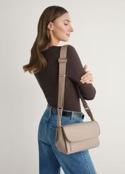 Beżowa klasyczna torebka damska TOREC-1124-1D(W26)- widok produktu z przodu, na modelce, na jasnym tle. Widoczna sylwetka do kolan.