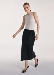 Czarna spódnica midi SPCDT-0114-99(Z25), widok produktu z przodu na modelce, widoczna cała sylwetka.