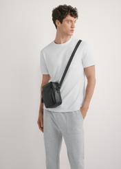 Czarna skórzana saszetka męska TORMS-0485R-9I(W26), widok produktu od przodu na modelu, widoczna połowa sylwetki.