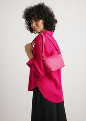 Mała torebka damska w kolorze fuksji TOREC-0882-5E(W26) - widok produktu z przodu, na modelce, na jasnym tle. Widoczna sylwetka do połowy.