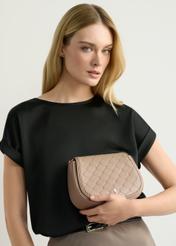 Beżowa listonoszka damska TOREC-1179-1P(W26), widok produktu w dłoni modelki. Widoczna połowa sylwetki.