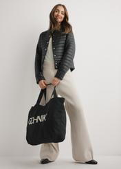 Czarna bawełniana torba TOREN-0136-9P(W26), widok produktu w dłoni modelki. Widoczna cała sylwetka.