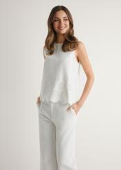 Biała bluzka damska BLUDT-0207-0B(W26), widok produktu z przodu na modelce. Widoczna połowa sylwetki.