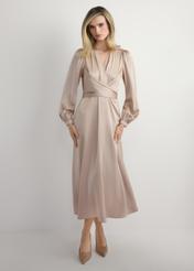 Długa beżowa sukienka midi SUKDT-0263-1B(W26) - widok produktu z przodu, na modelce, na jasnym tle. Widoczna cała sylwetka. 