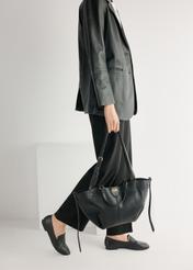 Skórzane czarne mokasyny damskie BUTYD-1074A-99(W26), widok produktu od przodu na modelce, widoczna połowa sylwetki.