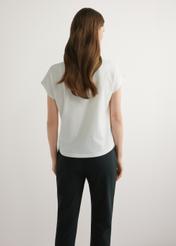 Kremowy T-shirt damski ze złotym nadrukiem TSHDT-0162-0B(W26), widok produktu z tyłu na modelce. Widoczna połowa sylwetki.