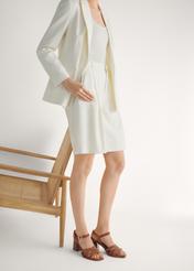 Zamszowe camelowe sandały damskie na słupku BUTYD-1231-1D(W26), widok produktu skosem na stopach modelki, na jasnym tle.