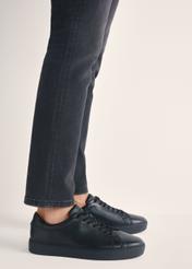 Czarne skórzane buty sportowe BUTYM-0503A-99(W26), widok produktu z boku na stopach modela.