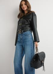 Czarny pikowany plecak damski TOREC-1115-99(W26), widok produktu w dłoni modelki, na jasnym tle.