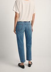 Ciemnoniebieskie spodnie jeansowe damskie JEADT-0011-7C(W26), widok produktu z tyłu na modelce. Widoczna połowa sylwetki.