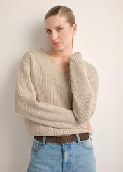Sweter damski w kolorze chłodnego beżu SWEDT-0162-1J(Z26), widok produktu z przodu na modelce. Widoczna połowa sylwetki. 