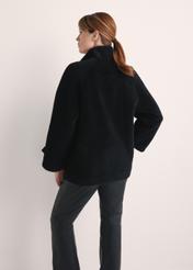 Wełniane futro damskie w kolorze czarnym FUTDW-0032-99(Z25) - widok produktu z tyłu na modelce na białym tle. Widoczna połowa sylwetki.