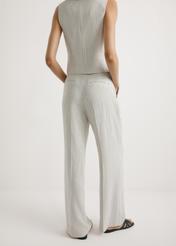 Szerokie spodnie damskie w paski SPODT-0123-0P(W26) - widok produktu z tyłu, na modelce, na jasnym tle. Widoczna połowa sylwetki.