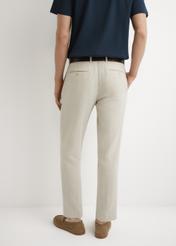 Beżowe spodnie garniturowe męskie w jodełkę SPOMT-0117-1B(W26), widok produktu z tyłu na modelu. Widoczna połowa sylwetki.