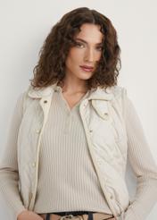 Jasnobeżowa pikowana kamizelka damska KAMDT-0036-0B(W26) - widok produktu z przodu, na modelce, na jasnym tle. Widoczna połowa sylwetki. 