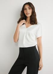 Kremowa bluzka damska BLUDT-0206-0B(W26), widok produktu z przodu na modelce. Widoczna połowa sylwetki.