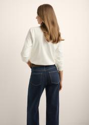 Kremowy bawełniany longsleeve damski LSLDT-0052-0B(Z26), widok produktu z tyłu na modelce. Widoczna połowa sylwetki.
