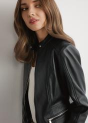 Czarna skórzana krótka kurtka damska KURDS-0603-99(W26) - widok produktu z przodu, na modelce, na jasnym tle. Widoczna połowa sylwetki. 