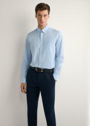 Bawełniana koszula męska w niebieską kratkę KOSMT-0277-7B(W26), widok produktu z przodu na modelu. Widoczna połowa sylwetki.