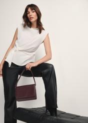 Skórzana torebka damska w kolorze bordowym TORES-1189-49(Z25), widok produktu w dłoni modelki na jasnym tle.