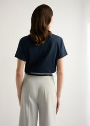 Granatowy t-shirt damski z bawełny merceryzowanej TSHDT-0154-7E(W26) - widok produktu z tyłu, na modelce, na jasnym tle. Widoczna sylwetka do kolan. 