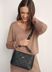 Czarna torebka damska z monogramem TOREC-1159-9P(W26), widok produktu od przodu na modelce, widoczna połowa sylwetki.