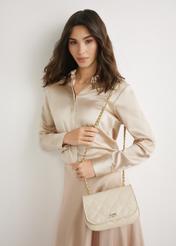 Kremowa skórzana lakierowana torebka damska TORES-1297-0B(W26), widok produktu z przodu na modelce. Widoczna sylwetka do kolan. 