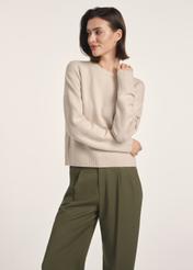 Beżowy sweter damski SWEDT-0242-80(Z25), widok produktu z przodu na modelce. Widoczna połowa sylwetki.
