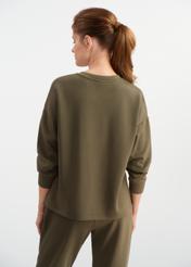 Bluza damska khaki BLZDT-0112-55(W25) - widok z tyłu na modelce, na białym tle. Widoczna cała sylwetka do połowy.