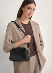 Czarna średnia torebka damska TOREC-1121-9I(W26), widok produktu od przodu na modelce, widoczna połowa sylwetki.