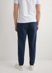 Granatowe męskie spodnie dresowe SPOMT-0109-7E(W26), widok produktu z tyłu na modelu. Widoczna połowa sylwetki.