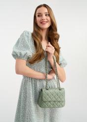 Zielona pikowana torebka damska TOREC-0932B-52(W25) widok na modelce przodem. Widoczna cała sylwetka.