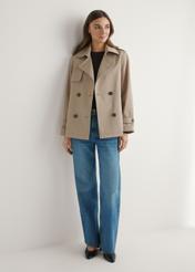 Beżowa krótka kurtka damska KURDT-0556-1C(W26), widok produktu z przodu na modelce. Widoczna cała sylwetka.