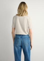 Jasnobeżowy T-shirt damski basic TSHDT-0120-1A(W26), widok produktu z tyłu na modelce. Widoczna połowa sylwetki.