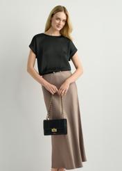 Mała torebka damska w kolorze czarnym TOREC-1186-99(W26) - widok produktu z przodu, trzymanego przez modelkę w ręku, na jasnym tle. Widoczna cała sylwetka. 