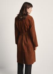 Brązowy zamszowy płaszcz damski oversize KURDS-0551-0775(Z25), widok produktu z tyłu na modelce. Widoczna połowa sylwetki.