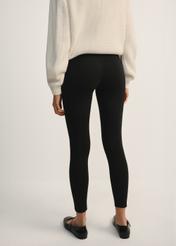 Czarne legginsy damskie LEGDT-0001-99(Z25), widok produktu od tyłu na modelce, widoczna połowa sylwetki.