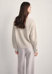 Beżowy sweter damski SWEDT-0238-81(Z25), widok produktu z tyłu na modelce. Widoczna połowa sylwetki.