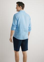 Niebieska lniana koszula męska KOSMT-0321A-7B(W26),  widok produktu z tyłu, na modelu, na jasnym tle. Widoczna połowa sylwetki. 