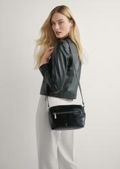 Czarna torebka damska na ramię TOREC-1207-9F(W26), widok produktu na ramieniu modelki. Widoczna połowa sylwetki.