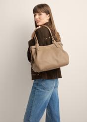 Skórzana torebka shopper w kolorze ciemnego beżu TORES-1360-1K(Z26) - widok produktu z przodu, na modelce, na jasnym tle. Widoczna sylwetka do kolan.