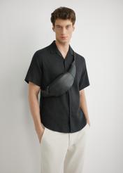 Czarna skórzana nerka męska TORMS-0497-99(W26), widok produktu z przodu na sylwetce modela.