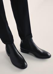 Czarne skórzane botki damskie BUTYD-0936A-99(Z25), widok produktu na stopach modelki na jasnym tle.