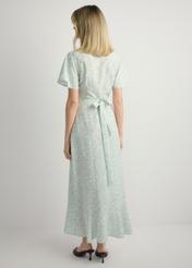 Długa sukienka w kwiaty SUKDT-0233-8P(W26), widok produktu z tyłu na modelce. Widoczna cała sylwetka.